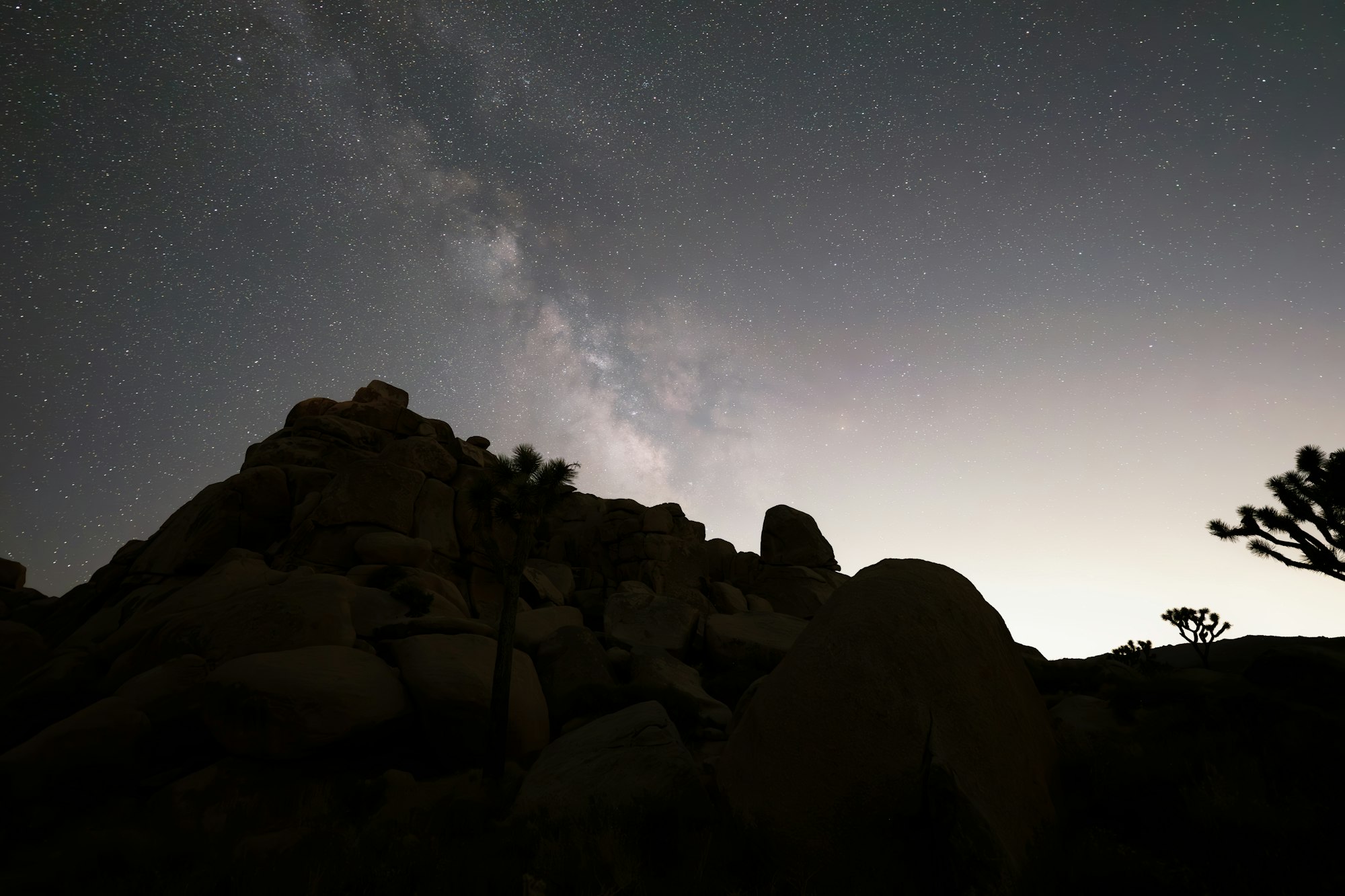 Milky Way arching over the rocky desert landscape at night